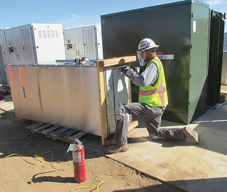 Photo 16. Electrician cutting the bottom out of a switchboard.