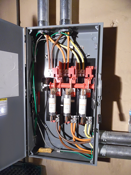 Photo 6. The supply-side connected conductors are connected to the load side of the fused disconnect, bottom. Additionally, the grounding electrode conductor is absent, the grounded conductor is not bonded at this location, and the green bond screw used for the main bonding jumper is still in the manila envelope in the bottom of the can. My question is, how do you replace a fuse without a shutdown? Very carefully.