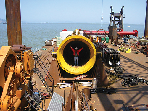 Photo 6. Standing in one of the world’s largest hydraulic pile driving hammers used in the SFO Bay Bridge project. The hammer creates 1.2 million pounds of force, which is equivalent to a vehicle hitting a solid wall at 265 MPH. 