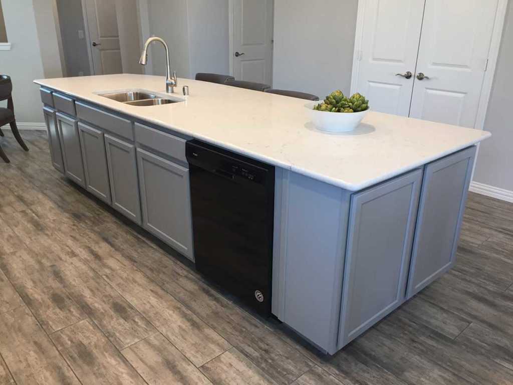 Photo 4. A long rectangular kitchen island with a sink and partial seating.