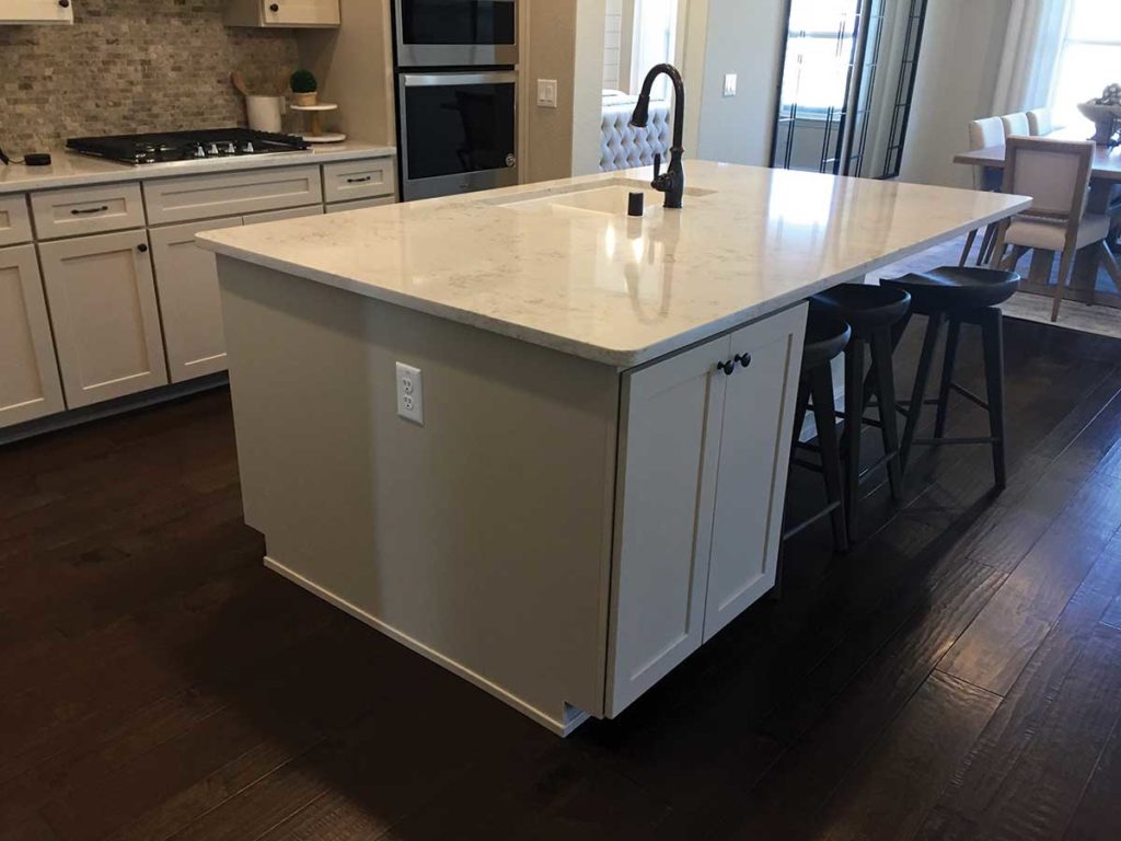 Photo 5. A rectangular kitchen island with a sink and partial seating.